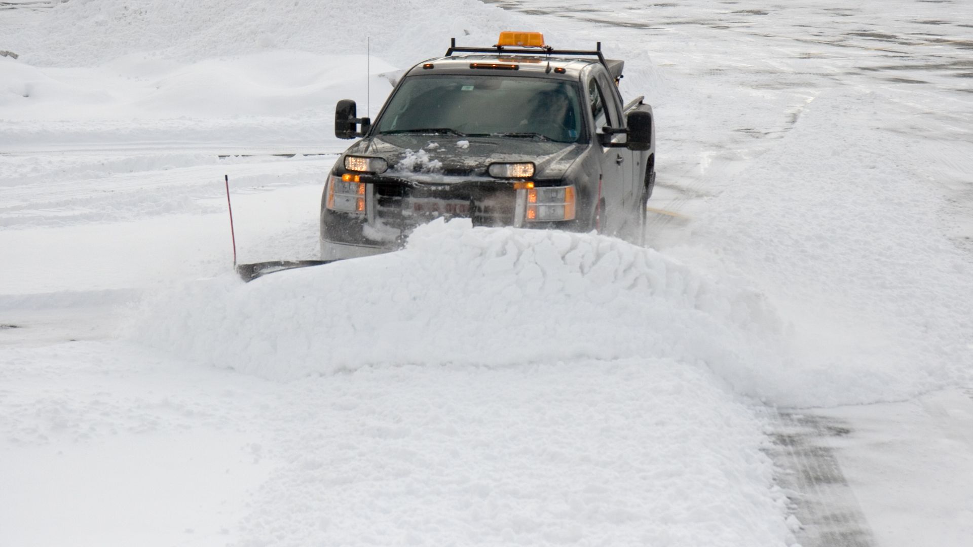 Snow plow clearing suburban driveway in Tinton NJ by Artistic Landscape Features